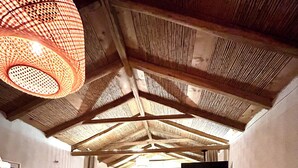 Une pièce chaleureuse avec un plafond en bois, un lit, une télévision et un escalier menant à un autre niveau.