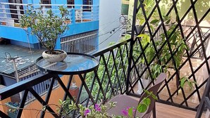 A balcony with a table, chairs, and potted plants. - ConiHouse III Thong Dong (Hue)