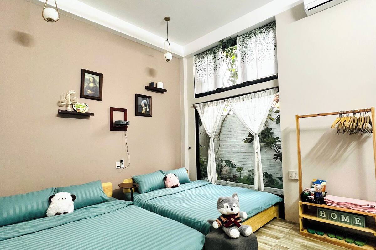 A modern bedroom with a large bed, a small table, and a window with curtains.