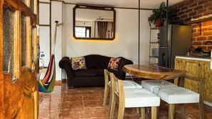 A cozy living area with a sofa, a round wooden table, and a bench. - Artisanal Amazonian Suite, A Natural Refuge in Puyo (Puyo)