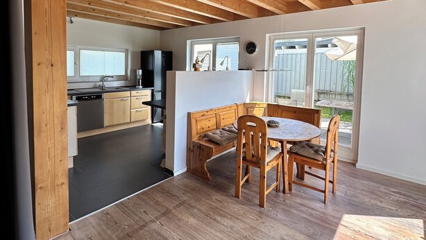 A spacious kitchen with modern appliances, a dining area with wooden furniture, and large windows providing natural light. - Vacation Rental with a Garden—Right Next to a Riding/Children's Farm (Attendorn)