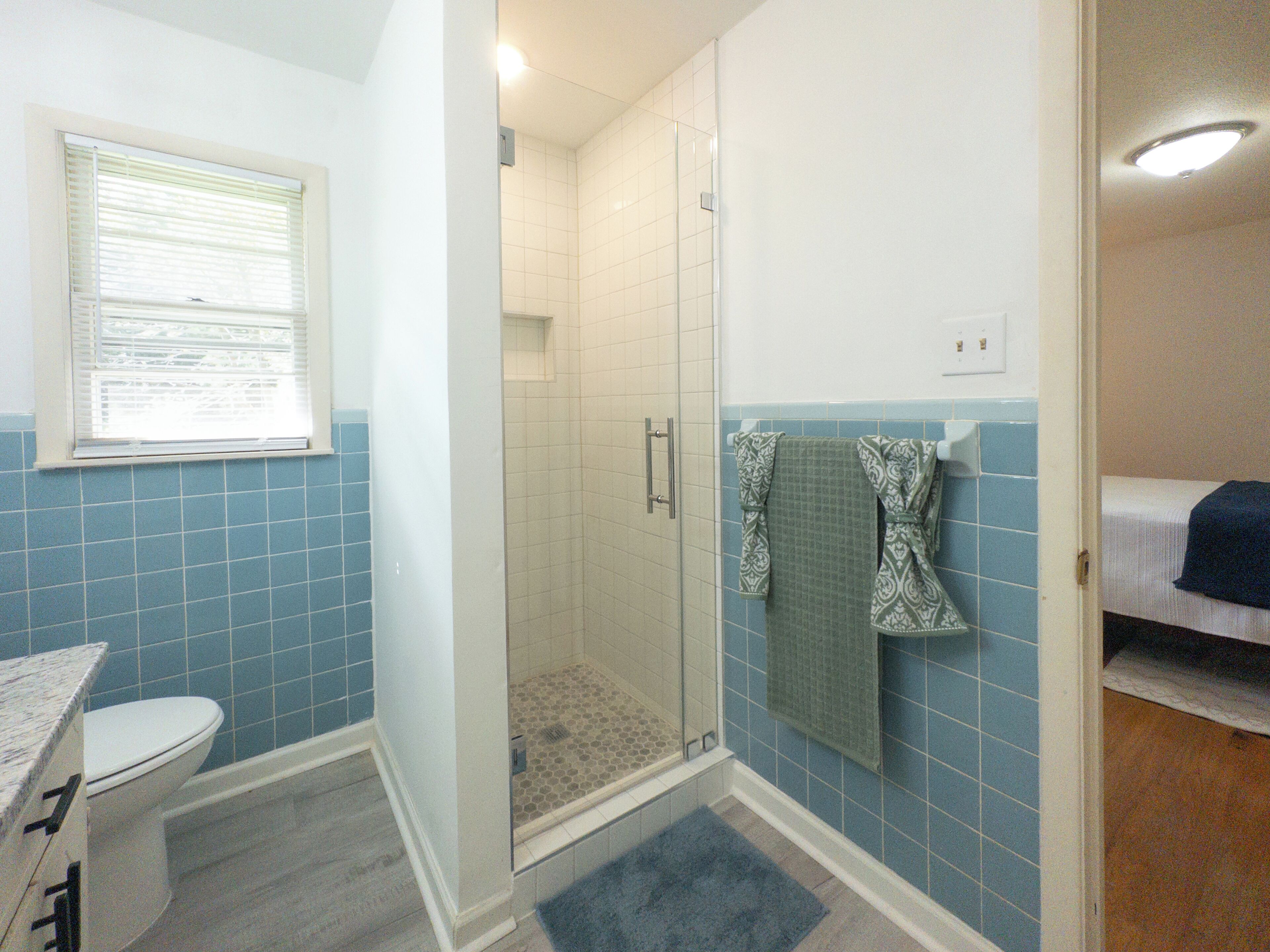 A bathroom with a toilet, a shower, and a sink.
