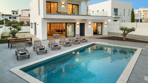 A modern two-story house with a swimming pool, outdoor seating, and a well-maintained garden. - Villa with heatable pool near the Marina (Quarteira)