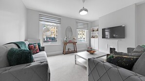 A modern living room with grey sofas, a coffee table, a TV, and a fireplace. - Shepherdess Place N1 🚇 Old Street 🚇 Angel (London)