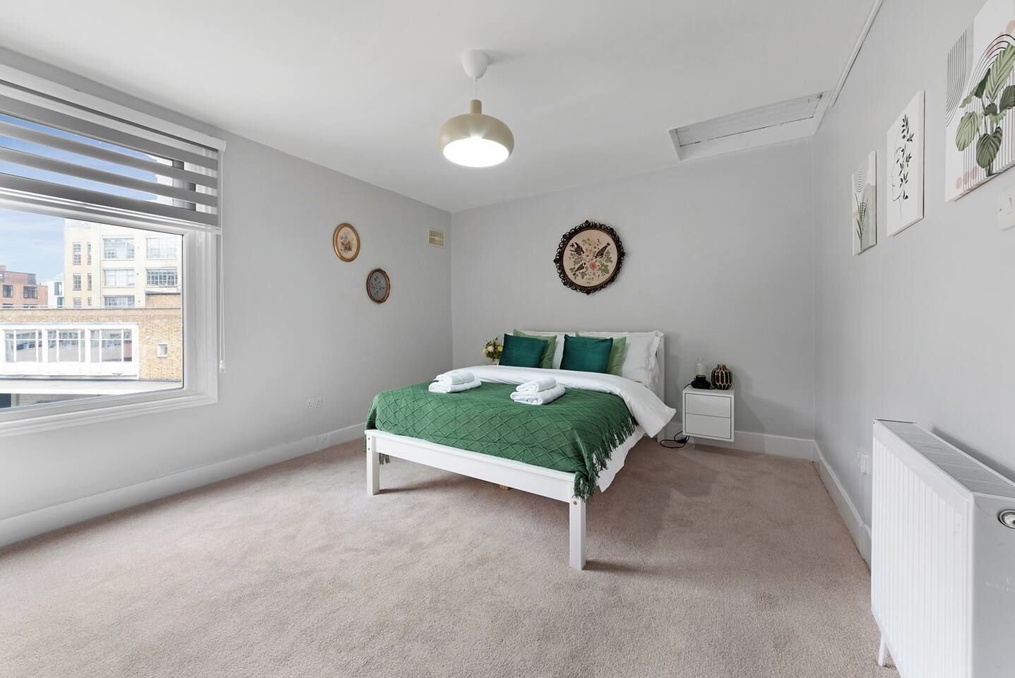 A bedroom with a bed, bedside table, and a radiator.