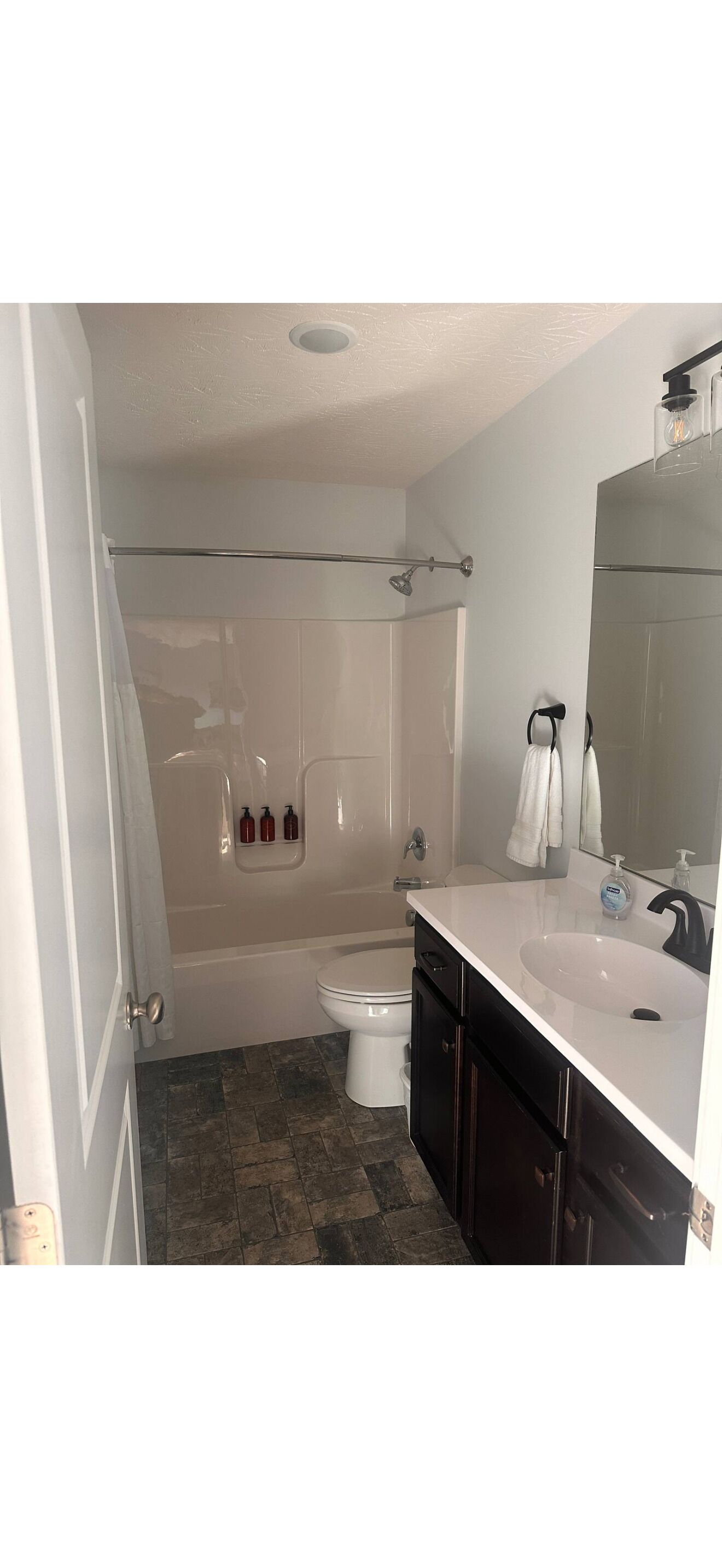 Une salle de bain avec une baignoire, des toilettes et un meuble-lavabo avec un miroir.