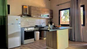Moderni keittiö, jossa on sisäänrakennettu uuni, jääkaappi ja puinen keittiösaareke.