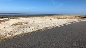 Una strada costiera con una spiaggia sabbiosa e cielo sereno.