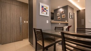 Una cocina moderna con una isla grande, armarios de madera y una lámpara colgante.