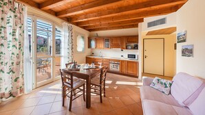 Una cocina acogedora con armarios de madera, una mesa de comedor y un sofá.