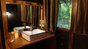 A bathroom with a wooden vanity, two sinks, a mirror, and a window with curtains. - Hotel Titas View Brahmanbaria (Brahmanbaria Sadar)