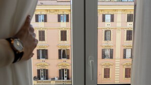 A view through a window of a building with multiple windows and balconies. - Eternal Suites Rome (Rome)