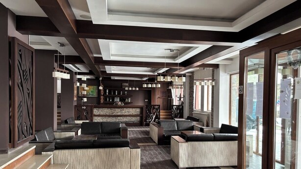 A modern lobby with a bar area, seating arrangements, and a staircase. - ✨ Elegant Mountain Apartment with Fireplace, Balcony Views, SKI In&Out ⛷ (Bansko)