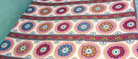 Un lit avec une couvre-lit à motifs, des oreillers et une tête de lit en bois.