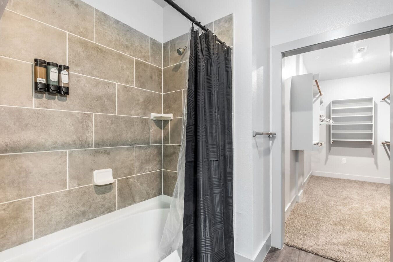 Ein Badezimmer mit Badewanne, Duschvorhang und Handtuchhalter.