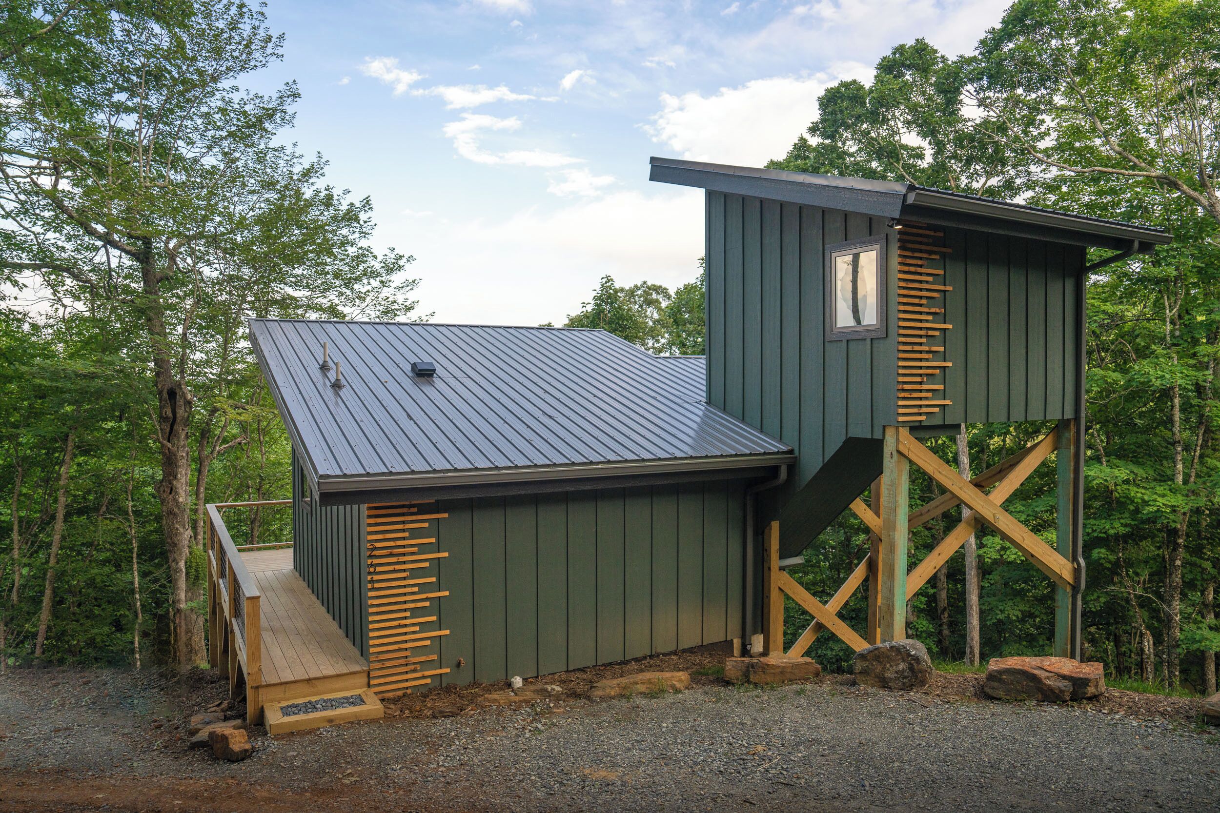 Eine Hütte mit Metalldach, Holzboden und einer Treppe zu einem Schlafbereich.