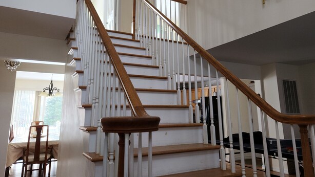 Una escalera de madera con barandillas blancas que conduce a un piso superior.