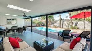 Ein modernes Wohnzimmer mit Pool, Sitzgelegenheiten im Freien und einem Essbereich.