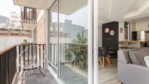 Un appartement moderne doté d’un balcon, d’un coin repas et d’un salon.