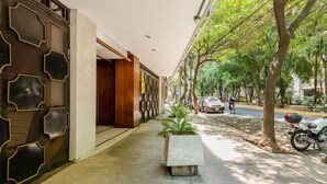 Un couloir au design moderne, avec un mur orné de motifs sur le côté gauche et un banc au centre.