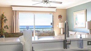 Una cucina moderna con vista sull'oceano, una ventola a soffitto e un'ampia finestra.