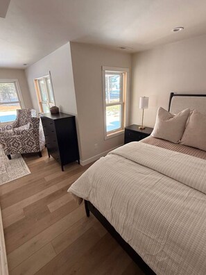 Une chambre à coucher avec un lit, un bureau, une chaise et une fenêtre.