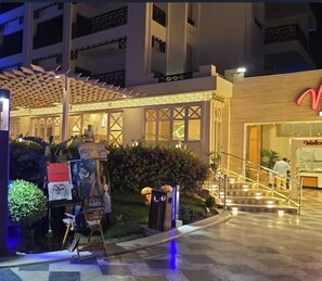 A hotel entrance with a well-lit facade, a reception desk, and a staircase leading to the lobby. - Sahl Hasheesh Finest Chalet Gravity 5 star beachfront hotel - NON EGYPTIAN ONLY (Hurghada)