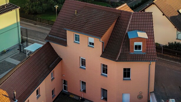 Un barrio residencial con casas, un lago y follaje otoñal.