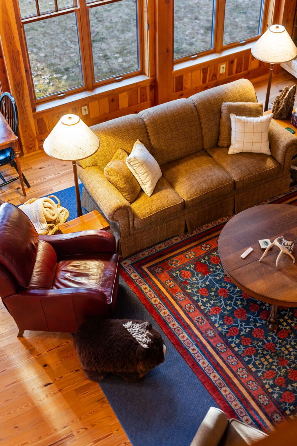 A cozy living room with a sofa, armchair, and a round table.