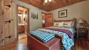 A wooden bedroom with a bed, a bench, and a nightstand.