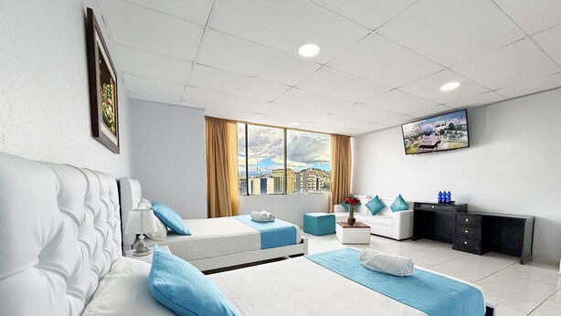 A hotel room with two beds, a sofa, a TV, and a window with curtains. - HOTEL SANTA MARIA BY LAUZA (Quito)