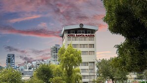 A hotel named 'Hotel Santa Maria' with a modern design, surrounded by greenery and urban buildings. - HOTEL SANTA MARIA BY LAUZA (Quito)