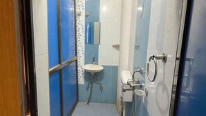 Une petite salle de bain comprenant des toilettes, un lavabo et une douche.