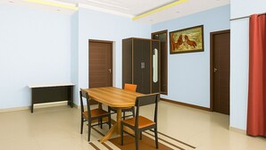 Une pièce spacieuse avec une table à manger en bois, des chaises, un banc et un tableau accroché au mur.