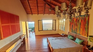 Une chambre spacieuse avec un grand lit, un plafond en bois et une vue sur l’extérieur.