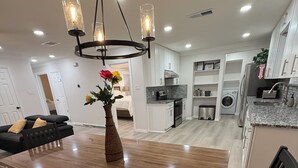 A modern kitchen with white cabinets, a stainless steel refrigerator, and a built-in oven. - Near AT&T • FIFA & Rangers • Sleeps 8 • Modern Home • Big Yard (Arlington)