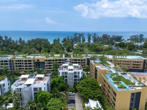 A residential complex with multiple buildings, a central courtyard, and a view of the ocean. - Suite Azure 2br | Laguna beachside bang tao beach (Choeng Thale)
