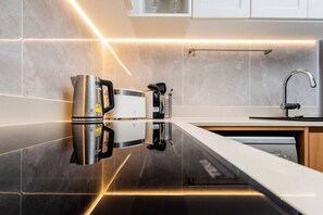 Una cocina moderna con un refrigerador de acero inoxidable, una cafetera y un lavavajillas.