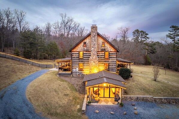 A log cabin with a stone chimney, a porch, and a gravel driveway. - LogRhythm Ultra Luxury 48Acre, 7Bed/6.5Bath estate (Massanutten)