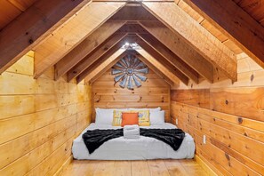 A cozy attic bedroom with a sloped ceiling, wooden walls, a bed with white bedding, and a decorative wooden ceiling design. - LogRhythm Ultra Luxury 48Acre, 7Bed/6.5Bath estate (Massanutten)
