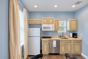 A compact kitchen with a refrigerator, microwave, and sink. - Walk to Historic Downtown, Sleeps 4, Dog Friendly, Off-street Parking (St. Augustine)