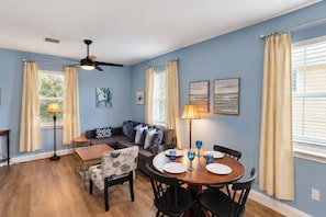 A dining area with a round table, chairs, and a ceiling fan. - Walk to Historic Downtown, Sleeps 4, Dog Friendly, Off-street Parking (St. Augustine)