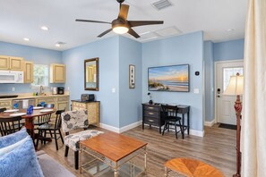 A well-lit kitchen with modern appliances, a dining area with a wooden table and chairs, and a ceiling fan. - Walk to Historic Downtown, Sleeps 4, Dog Friendly, Off-street Parking (St. Augustine)