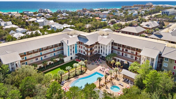 Un complex turístic amb diversos edificis, una piscina i vistes a l'oceà.
