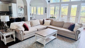 A spacious living room with a large sectional sofa, a coffee table, and a patterned rug. - 7BR Ski & Golf Course Retreat with Hot Tub (Flagstaff)