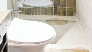 Un baño con ducha, inodoro y lavabo.