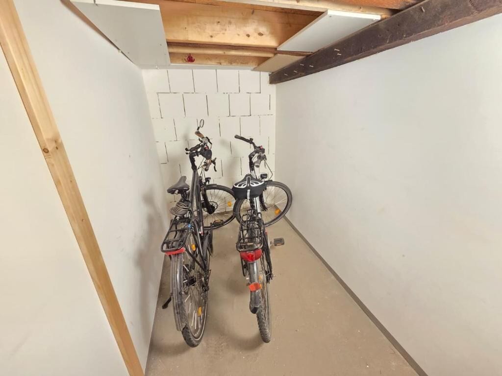 Un pasillo estrecho con dos bicicletas estacionadas contra la pared.