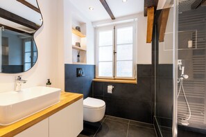 A modern bathroom with a wooden vanity, a white sink, a toilet, and a glass shower enclosure. - Fachwerk Boutique Hotel by corents (Hattingen)