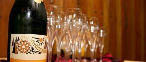 A bottle of wine with a label, surrounded by empty wine glasses on a table.