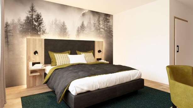 Un dormitorio moderno con una cama grande, una mesita de noche, una silla y un mural de árboles en la pared.